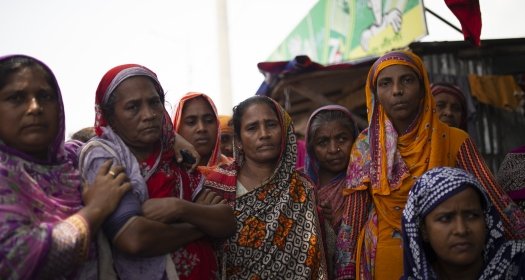 Bangladeshi women stand together outside.