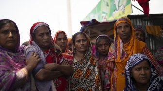 Bangladeshi women stand together outside.