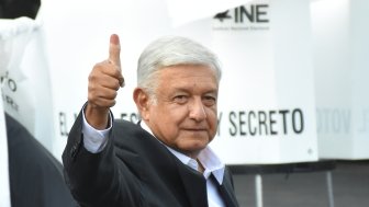 AMLO gives a thumbs up with his ink-stained finger.