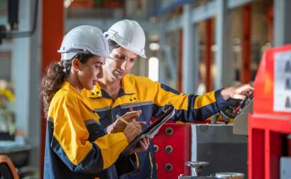 Two factory employees work together onsite