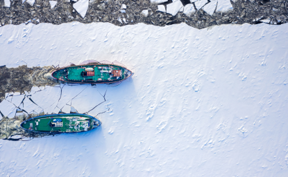 Ice breakers crush through the ice in an aerial shot