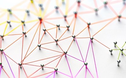 Linking entities. Networking, social media, SNS, internet communication abstract. Small network connected to a larger network. Web of red, orange and yellow wires on white background.