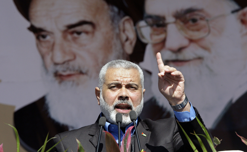 Visiting Hamas prime minister from Gaza, Ismail Haniyeh, gestures as he delivers his speech in front of portraits of late Iranian revolutionary founder Ayatollah Khomeini, left, and supreme leader Ayatollah Ali Khamenei, at a rally in Tehran.