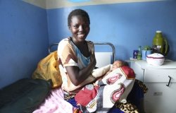 A Kenyan woman and her newborn baby in a maternity ward