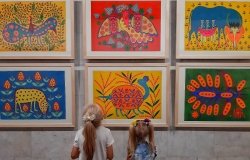 Two girls at an exhibition of paintings by Maria Prymachenko. 