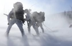 Soldiers walking through snow in the Arctic