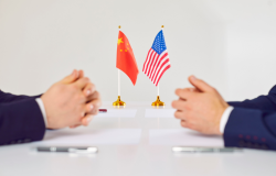 Flags of America and China stand on table during talks between diplomats