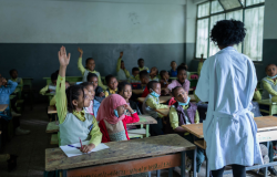 In a classroom in Ethiopia, a group of students raise their hands to share stories about their summer break.