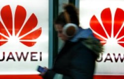 A young woman walks past to advertisement light boxes with Huawei logo in Kiev, Ukraine.