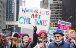 Group of people walking together – sign reads “Women’s Rights are Civil Rights” in Midtown Manhattan during the NYC Women’s March – New York, NY, USA January 1/19/2019 Women’s March.