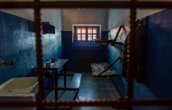 Empty prison cell in Russia. Two beds, a table, a washstand and a toilet are behind bars.