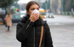 COVID-19 Pandemic Coronavirus Woman in city street wearing protective face mask 