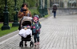 A mother and child walk down the street in Russia, October 2020