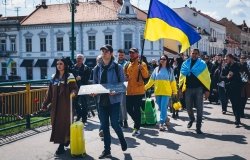 Protesters walking down street with Ukrainian Flags